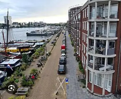 a view of a marina with cars parked next to a building at Near Amsterdam central station in Amsterdam