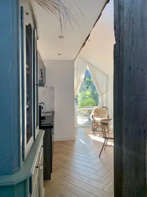 a kitchen with white walls and a wooden floor at La Bastide in Heiloo