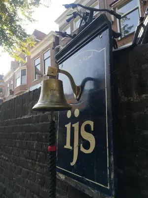 a bell on the side of a brick wall at La Bastide in Heiloo