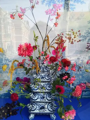 a blue and white vase with flowers in it at La Bastide in Heiloo