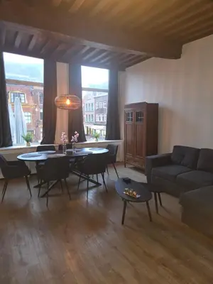 a living room with a table and a couch at Slapen bij De Buren in Alkmaar