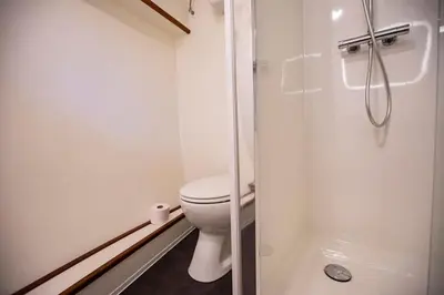 a white bathroom with a toilet and a shower at Marie's Houseboat in Amsterdam