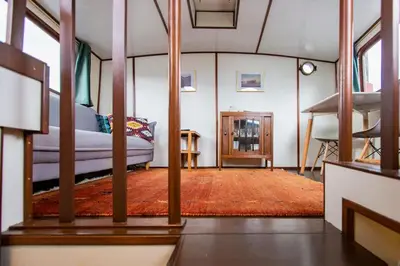 a living room with a bed and a rug at Marie's Houseboat in Amsterdam