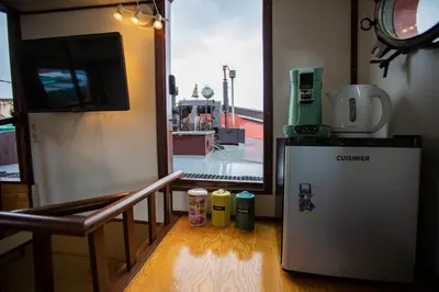 a small refrigerator in a room with a window at Marie's Houseboat in Amsterdam