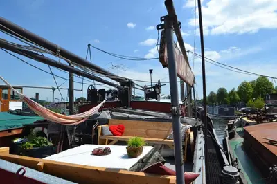 a boat with a hammock on the deck at Marie's Houseboat in Amsterdam