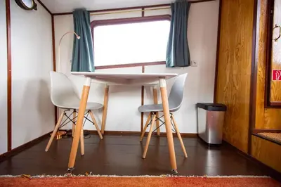 a table and two chairs in a room with a window at Marie's Houseboat in Amsterdam