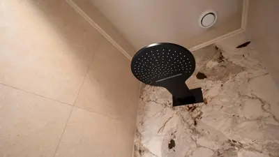 a bathroom floor with a black fan on the floor at B&B Blaauw - Raadhuis Suite in Heemstede