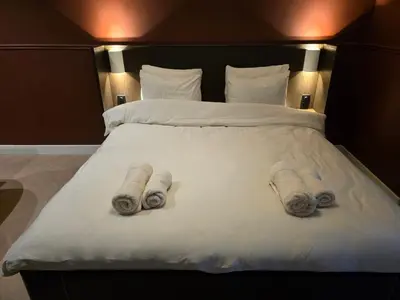 a bedroom with a bed with two towels on it at B&B Blaauw - Raadhuis Suite in Heemstede