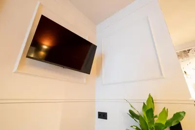 a flat screen tv hanging on a wall at B&B Blaauw - Raadhuis Suite in Heemstede