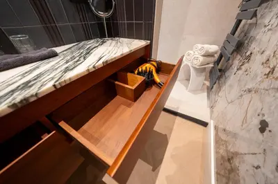 a room with a bed with a wooden bench at B&B Blaauw - Raadhuis Suite in Heemstede