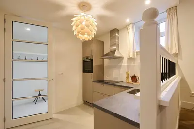 a kitchen with a staircase and a chandelier at Appartement C Rosita in Twisk