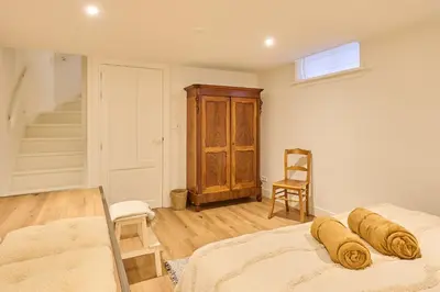 a bedroom with a bed and a chair and stairs at Appartement C Rosita in Twisk