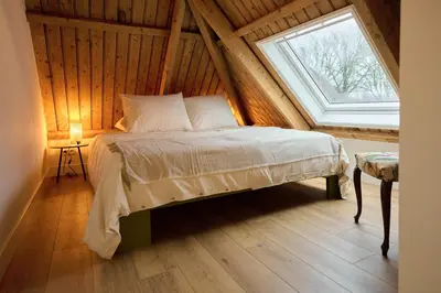 a bedroom with a bed and a window in a attic at Appartement C Rosita in Twisk