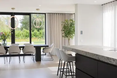 a kitchen and dining room with a table and chairs at Elements The Residence Luxe villa en guesthouse in Bergen