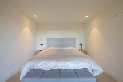 a large white bed in a white bedroom at Elements The Residence Luxe villa en guesthouse in Bergen