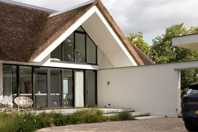 a house with white walls and windows at Elements The Residence Luxe villa en guesthouse in Bergen