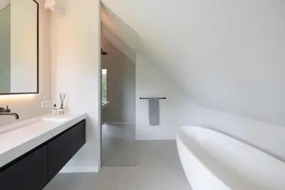 a white bathroom with a tub and a sink at Elements The Residence Luxe villa en guesthouse in Bergen