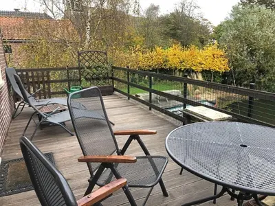 a deck with chairs and a table and a table and chairs at Apartment by the water in Broek op Langedijk