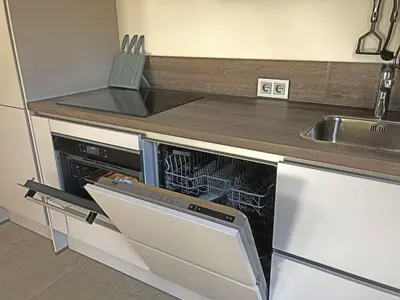 a small kitchen with a dishwasher and a sink at Apartment by the water in Broek op Langedijk