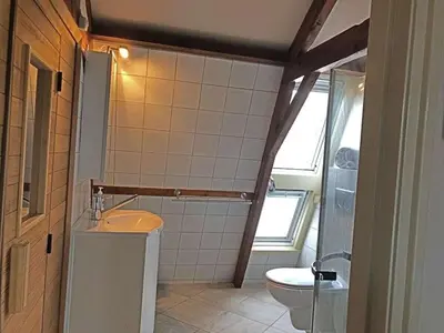 a bathroom with a sink and a toilet at Apartment by the water in Broek op Langedijk