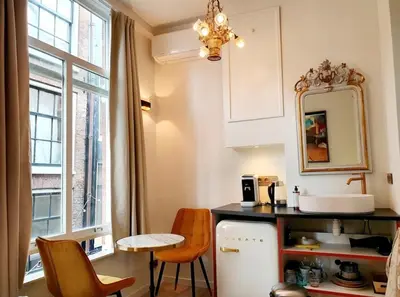a kitchen with a table and chairs and a window at As Home in Amsterdam