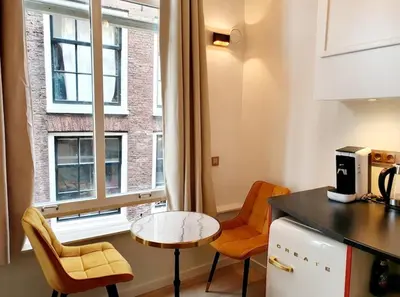 a kitchen with a table and chairs and a window at As Home in Amsterdam