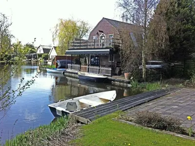 a boat is docked at a house on a river at 