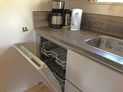 a kitchen counter with a dish drying rack next to a sink at 