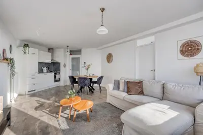 a living room with a couch and a table at Comfortable Stay Near The Coast in Burgerbrug
