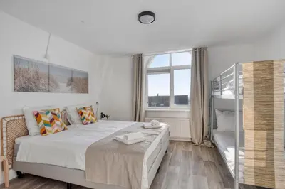 a white bedroom with a bed and a window at Comfortable Stay Near The Coast in Burgerbrug