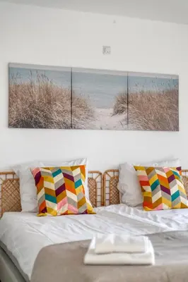 a bedroom with a bed with a picture of a beach at Comfortable Stay Near The Coast in Burgerbrug