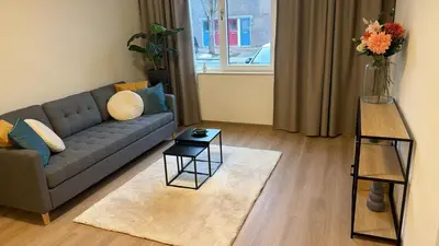 a living room with a couch and a vase of flowers at Lely in Lelystad