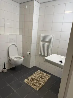 a white bathroom with a toilet and a sink at Lely in Lelystad