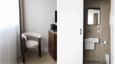 a bathroom with a white chair and a sink at Dam Residence - Boutique Hotel in Zaandam