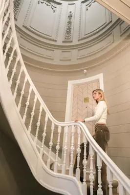 a woman is walking down the stairs at Dam Residence - Boutique Hotel in Zaandam