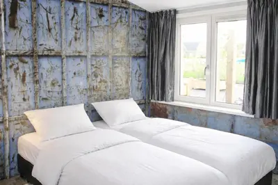 two beds in a room with two windows at De Beemster | Group accommodation near Amsterdam in West-Graftdijk