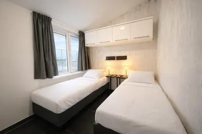 two beds in a room with a window at De Beemster | Group accommodation near Amsterdam in West-Graftdijk