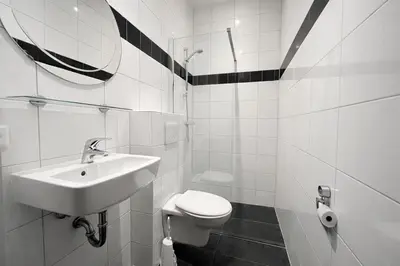a white bathroom with a sink and a toilet at De Beemster | Group accommodation near Amsterdam in West-Graftdijk