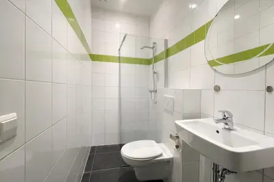 a bathroom with a toilet and a sink and a mirror at De Beemster | Group accommodation near Amsterdam in West-Graftdijk