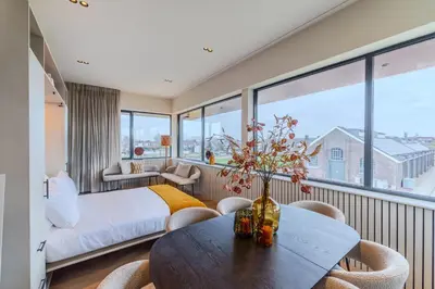 a bedroom with a bed and a table with chairs at Seinhuis Post VI in Amersfoort