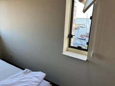 a bedroom with a window with a view of a harbor at Fokkeboom in Almere