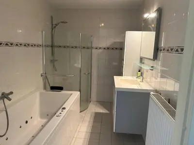 a bathroom with a shower and a tub and a sink at Fokkeboom in Almere