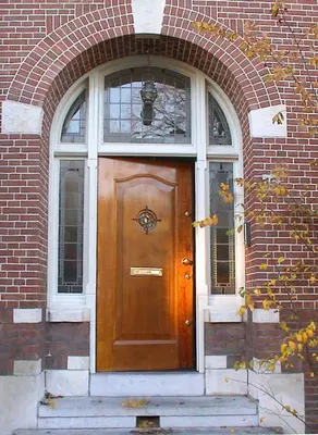 a wooden door in a brick building with a window at Top Floor Apartment Vondelpark in Amsterdam