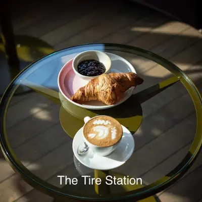 a glass table with a cup of coffee and a plate with a pastry at Top Floor Apartment Vondelpark in Amsterdam