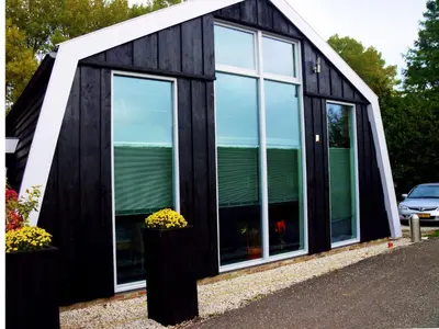a black and white house with large windows at Holiday Home Markermeerlogies by Interhome in Bovenkarspel