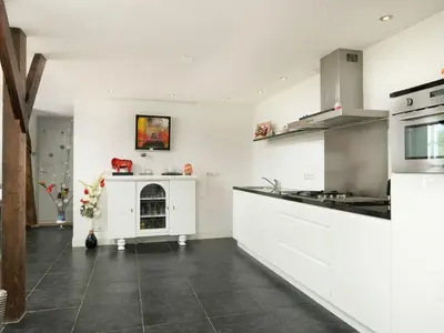 a kitchen with white cabinets and a stove at Holiday Home Markermeerlogies by Interhome in Bovenkarspel