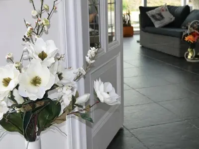 a vase filled with white flowers next to a door at Holiday Home Markermeerlogies by Interhome in Bovenkarspel