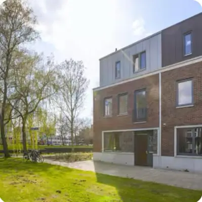 a large brick building with a grass yard next to it at Studio Mokum in Amsterdam