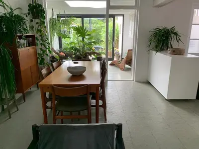 a dining room with a table and some plants at Botanico - family house in Egmond aan Zee