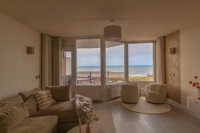 a living room with a couch and a view of the ocean at Casa Amare in Egmond aan Zee